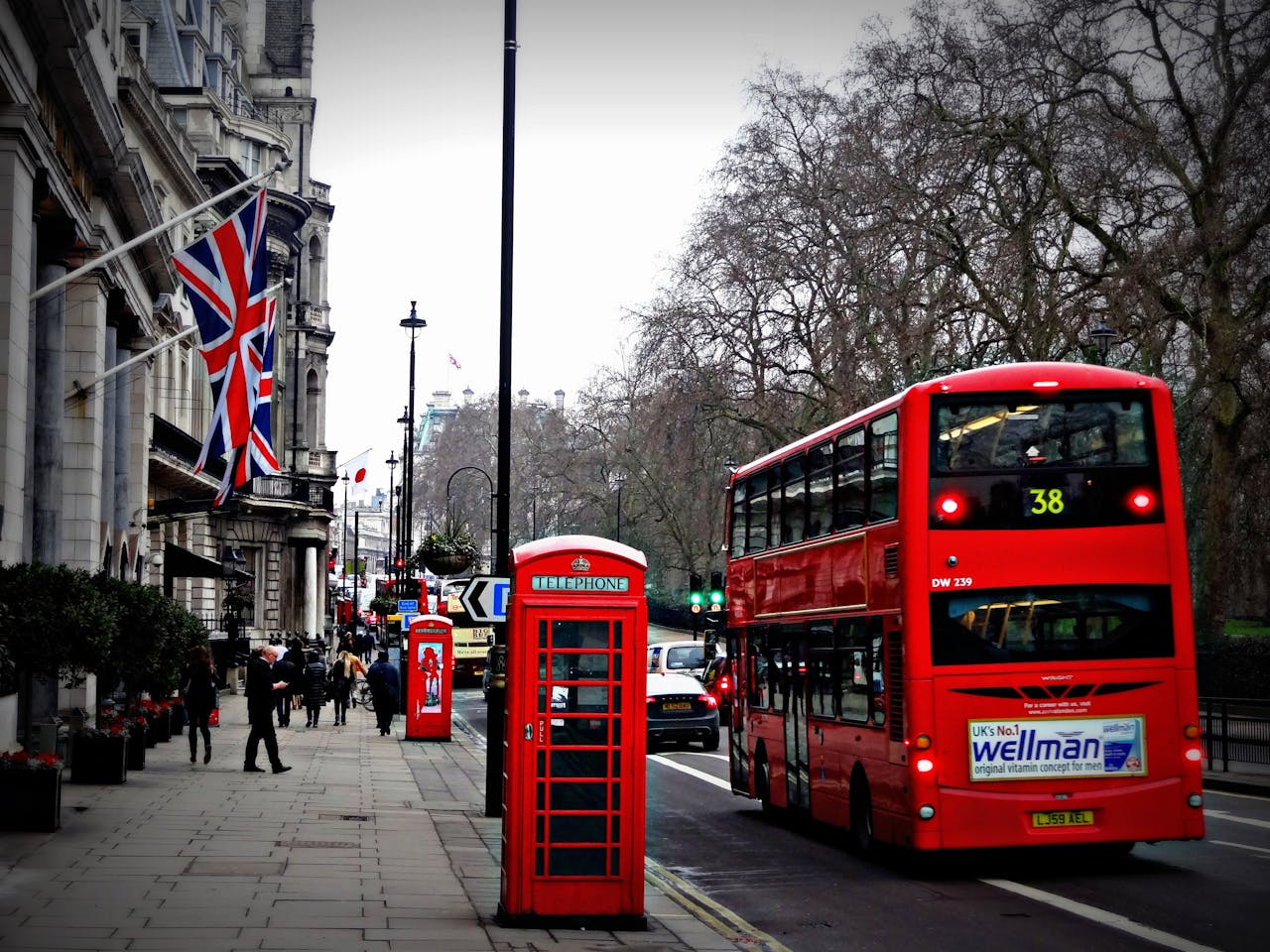 Services-03 Classic London scene featuring a red double-decker bus and iconic phone booth on a busy city street.