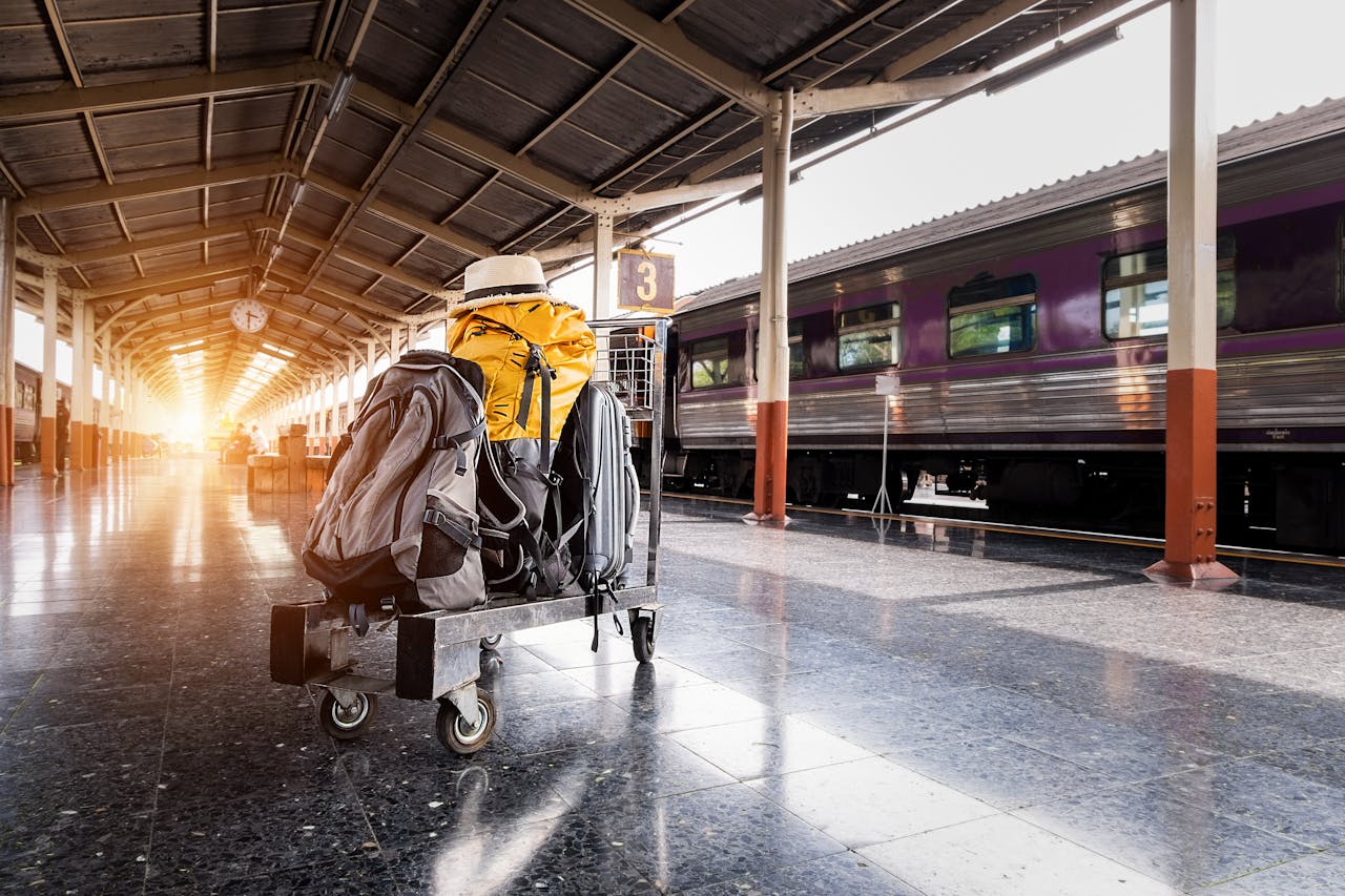 Services-02 A traveler's baggage cart on an urban railway station platform at sunrise.